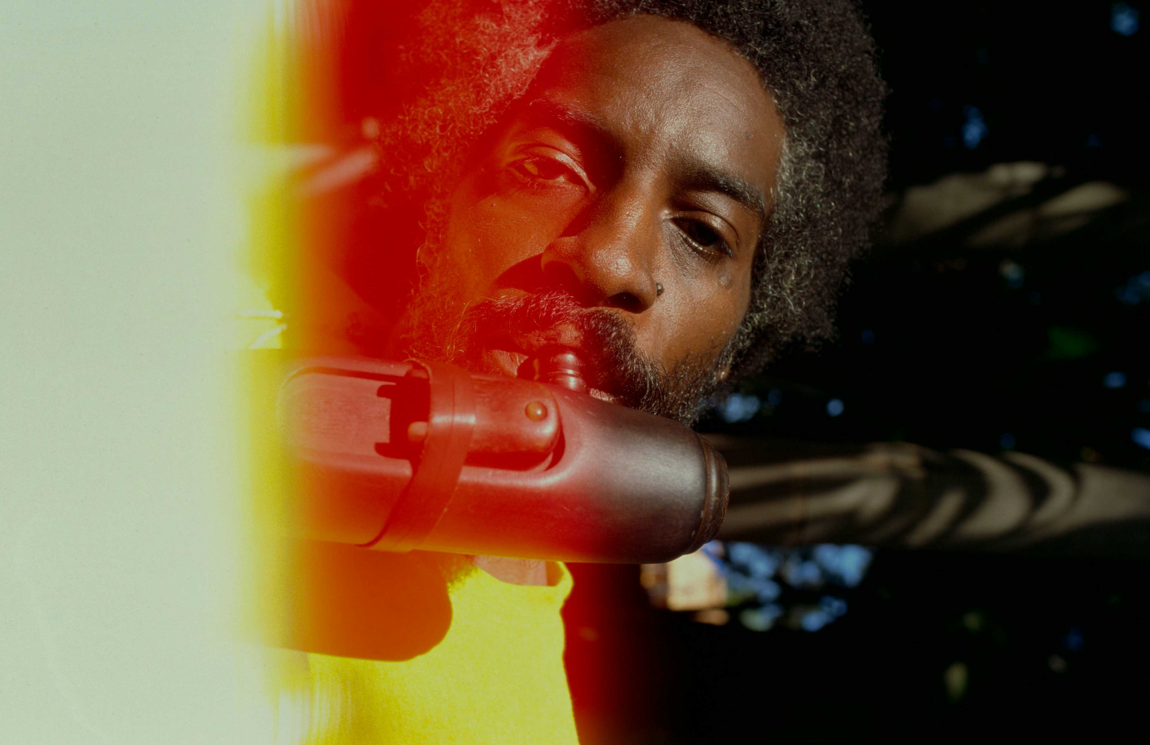 Bilde av artisten André 3000 som spiller fløyte